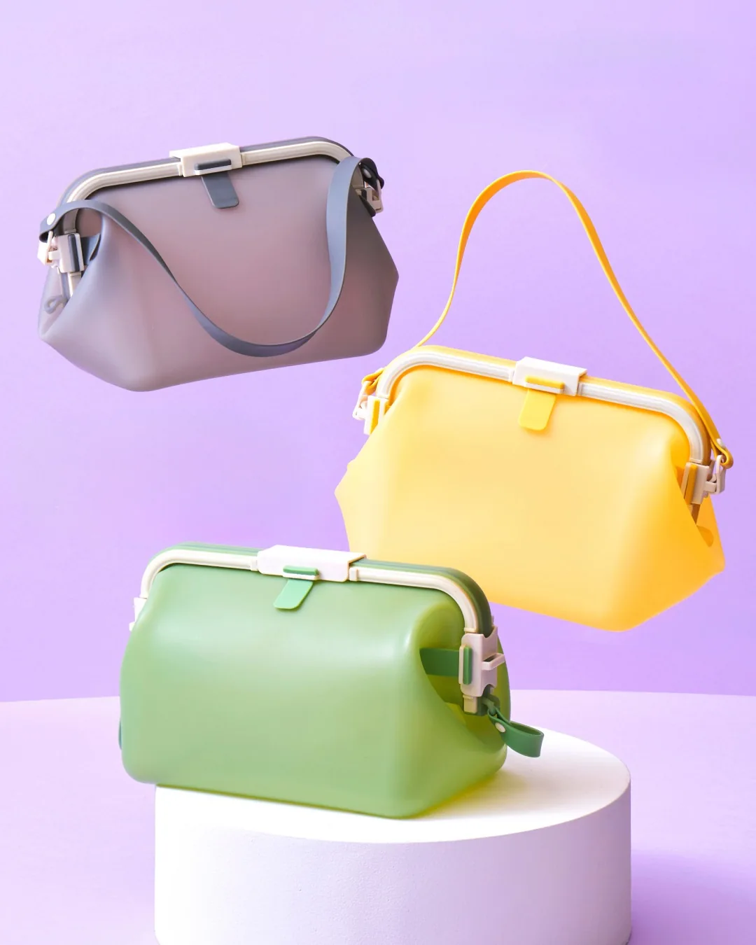 Lavender, yellow and green silicone bags displayed on colored plinths