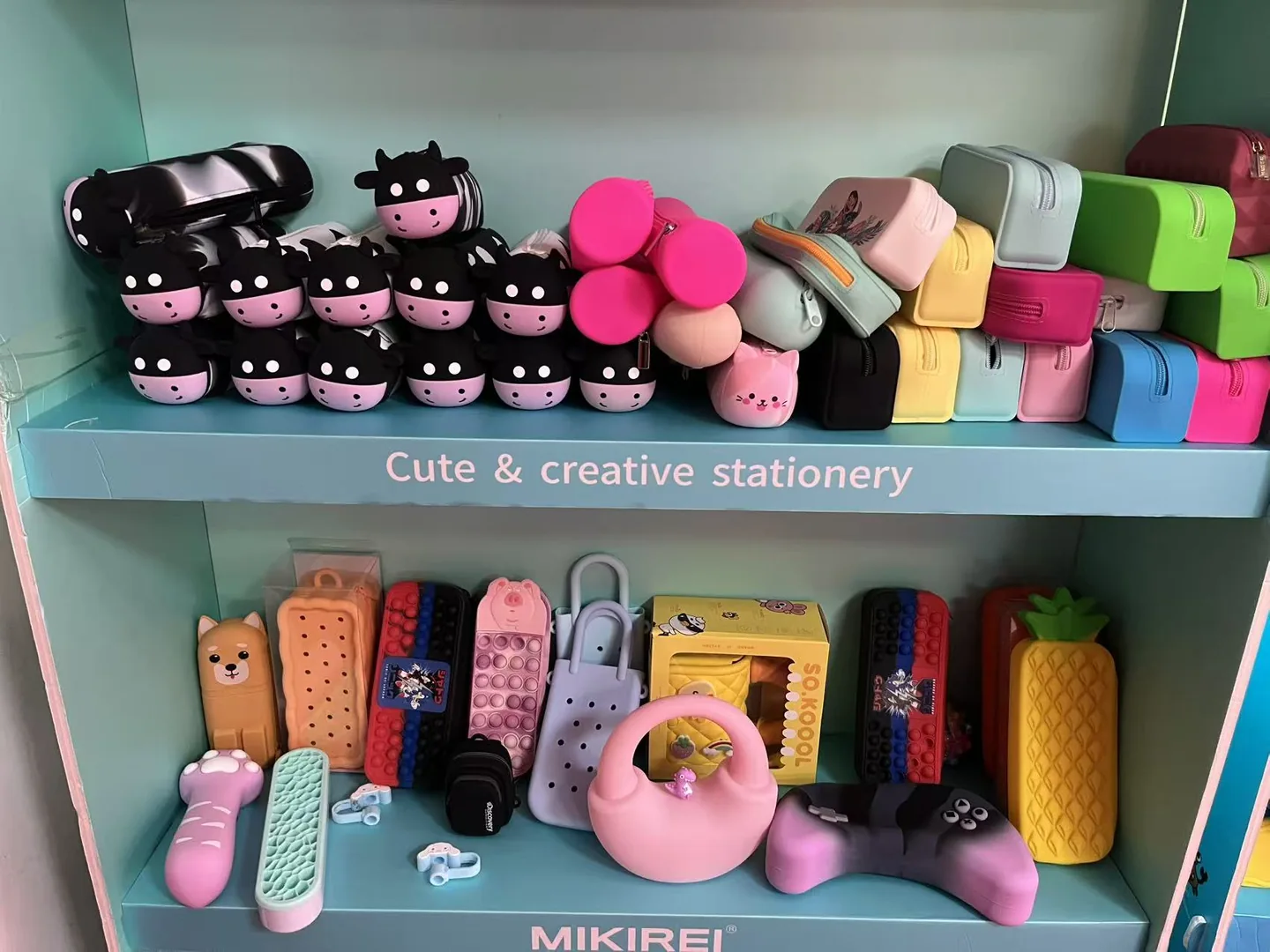 Showroom shelves displaying colorful silicone pouches and stationery cases